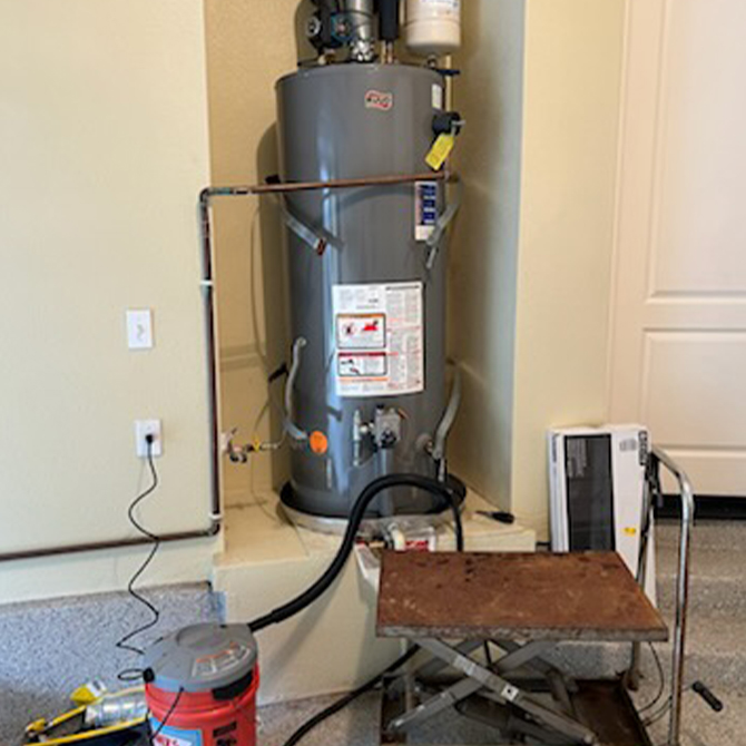 Technician setup for water heater repair with residential tank system, tools, and drainage equipment for professional hot water system service.